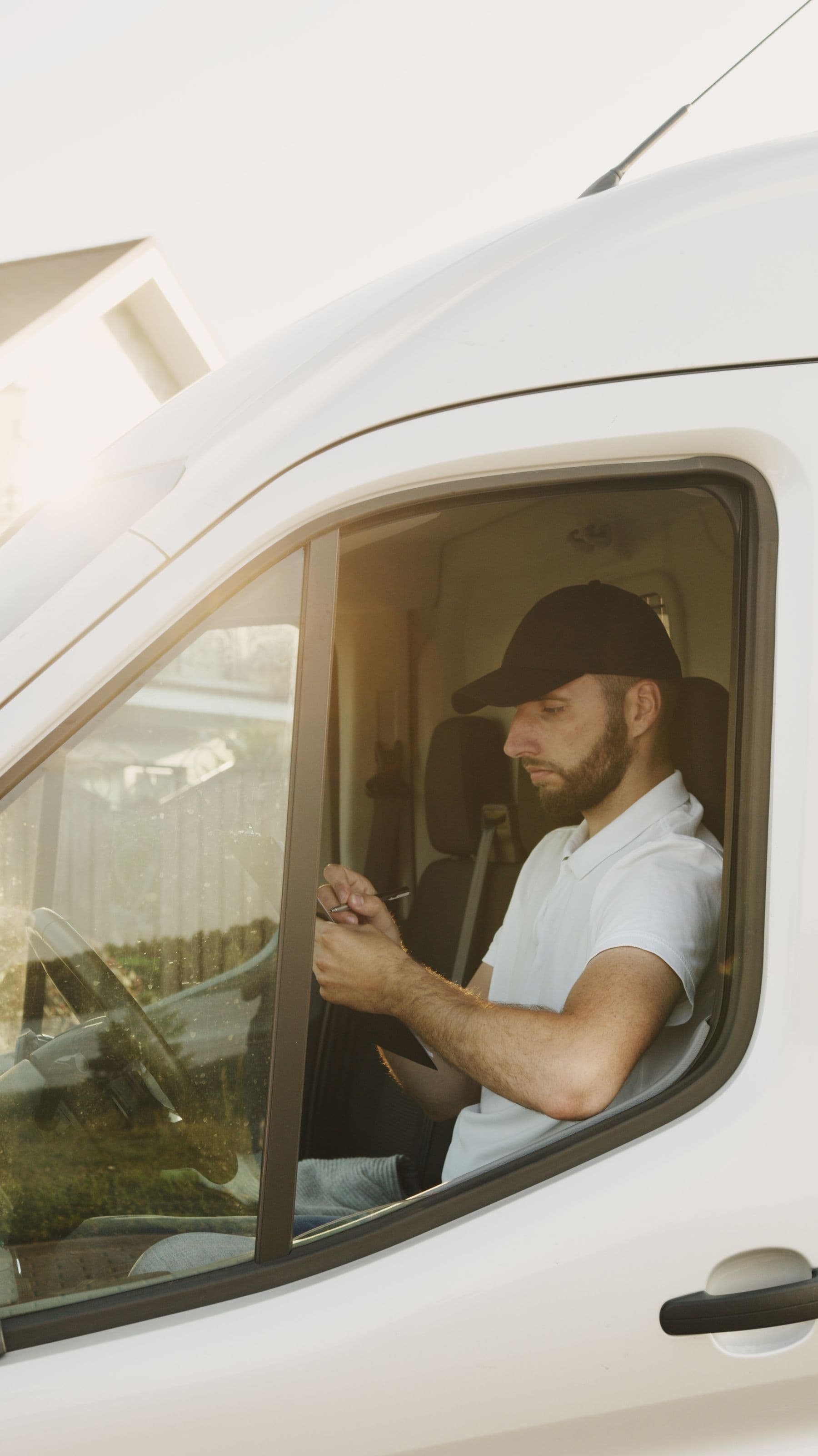 Technician in the cab of a work van filling out a job sheet