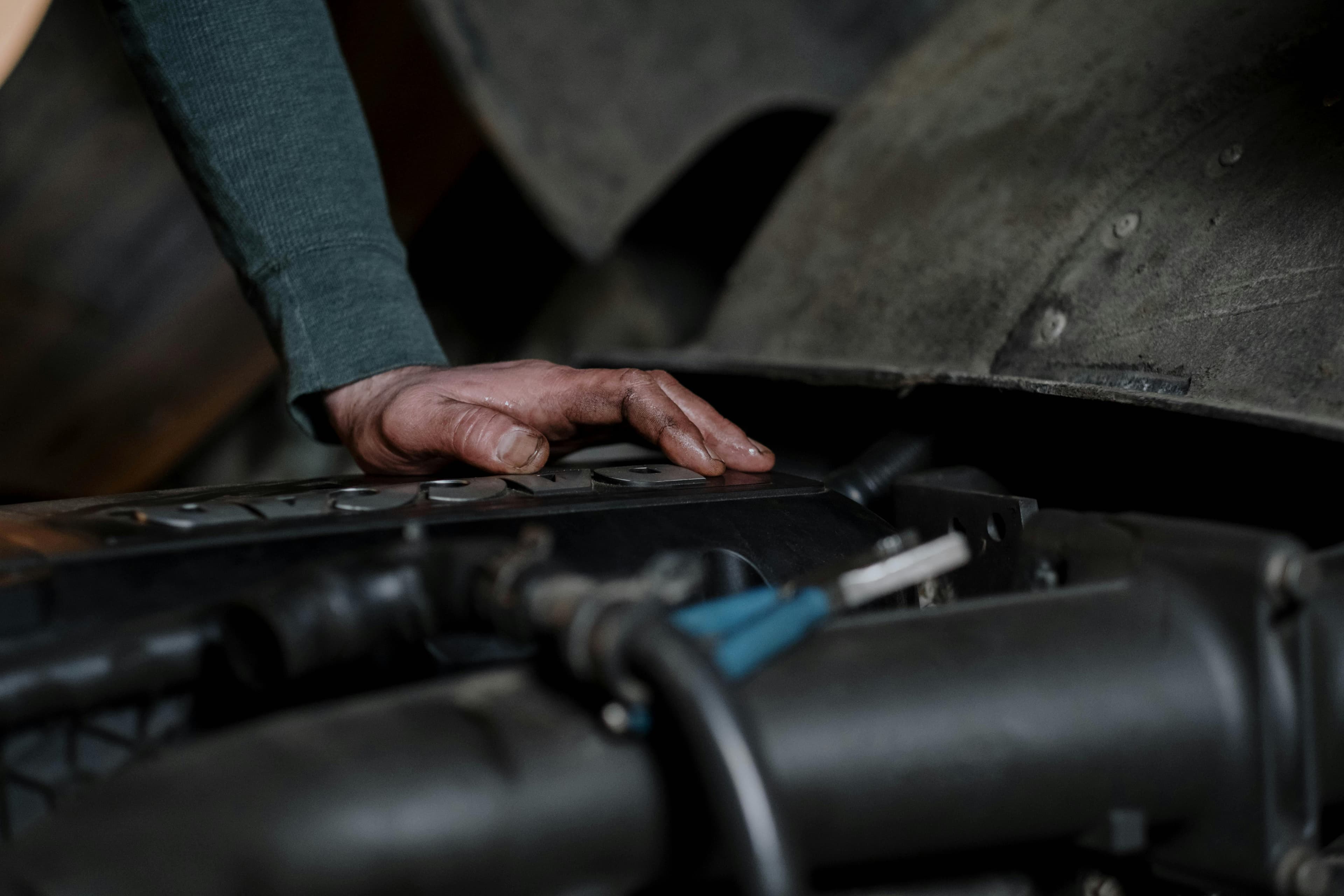 Close-up of a mechanic's hand on a Toyota engine block